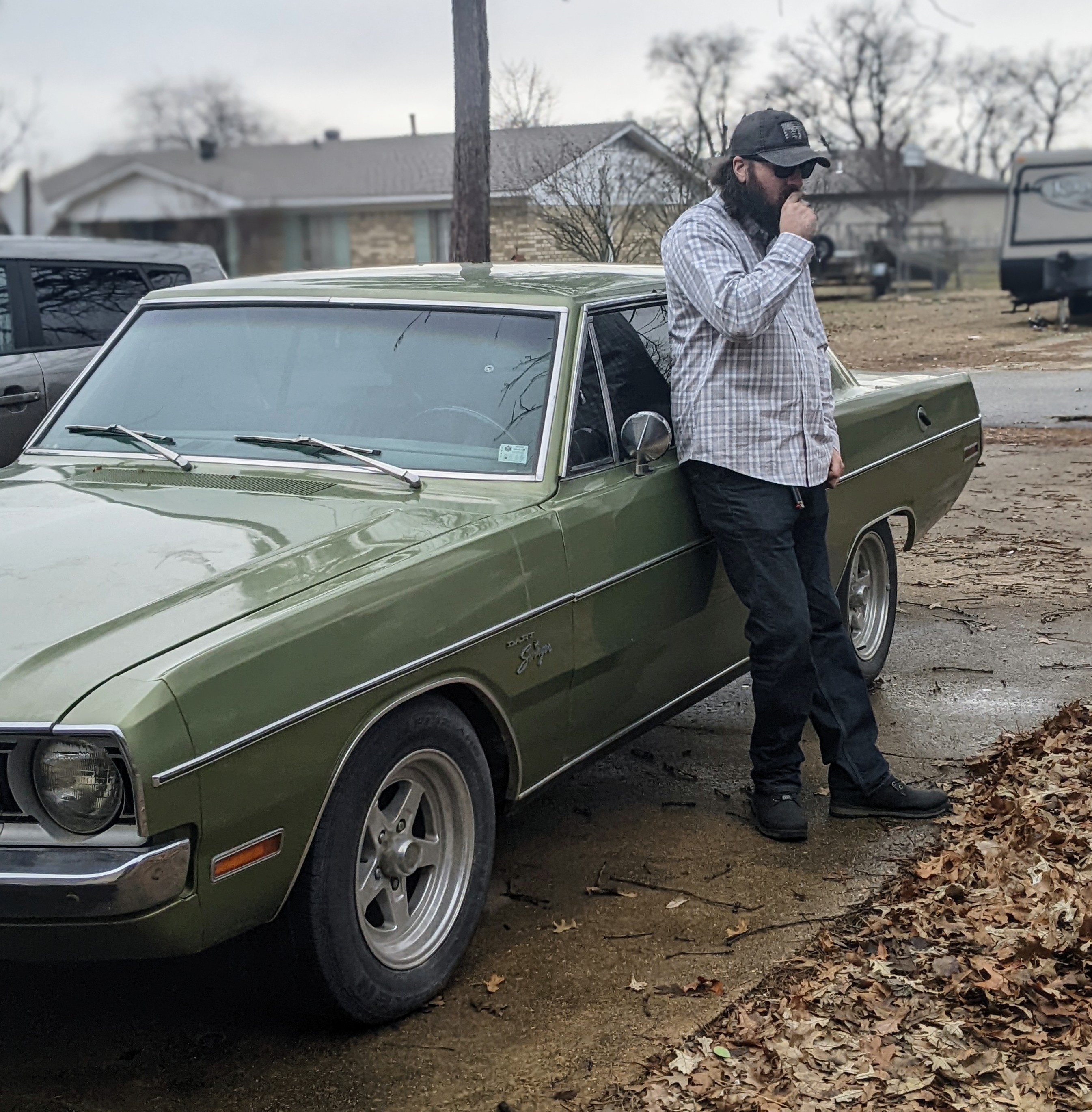 Chris leaning against a green classic car