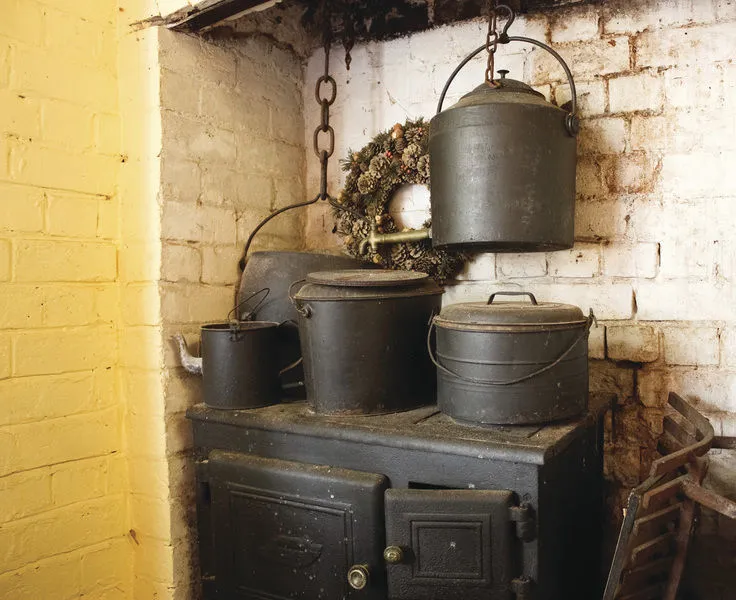 Cast-iron cookstove with kettles adding moisture while cooking
