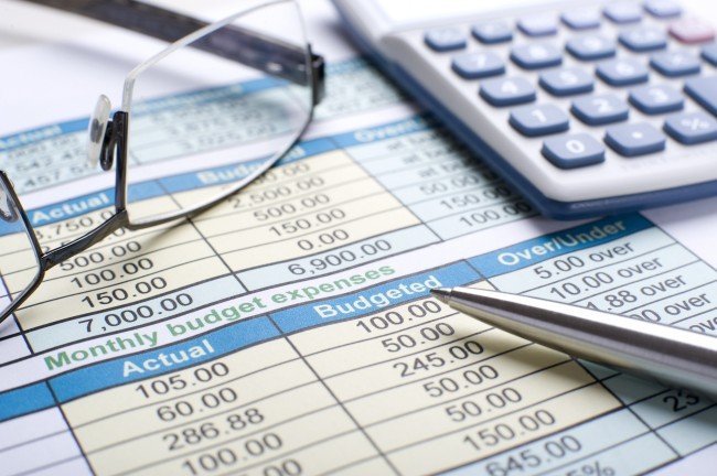 Budget spreadsheet with calculator and glasses—plan winter heat upgrades by tier